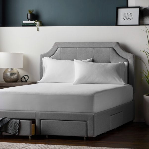 "White Prime Classic mattress protector fitted on bed with deep pocket elastic for secure fit"